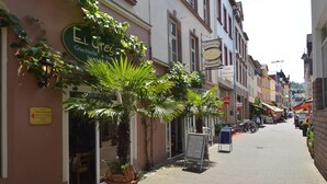 A street with buildings, a sign for a restaurant, and a potted plant. - Lovely Modern Apartment, Near the Mosel, Shops and Restaurants (Zell (Mosel))