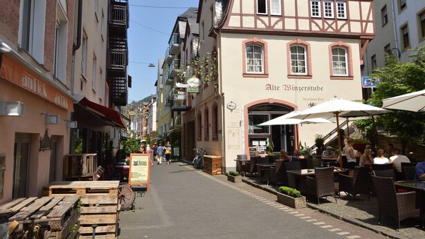 A street with outdoor seating, a building with 'Alte Winzerstube' signage, and a clear sky. - Lovely Modern Apartment, Near the Mosel, Shops and Restaurants (Zell (Mosel))