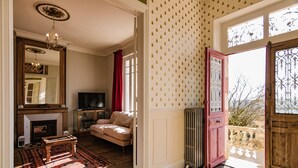 Un salon avec une cheminée, un canapé, une télévision et un plancher en bois.