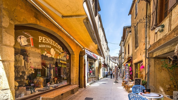 A narrow street with shops, a café with outdoor seating, and a sign for 'Penelop Mercerie Cade.' - Blanquefort Hill Retreat (Blanquefort-sur-Briolance)