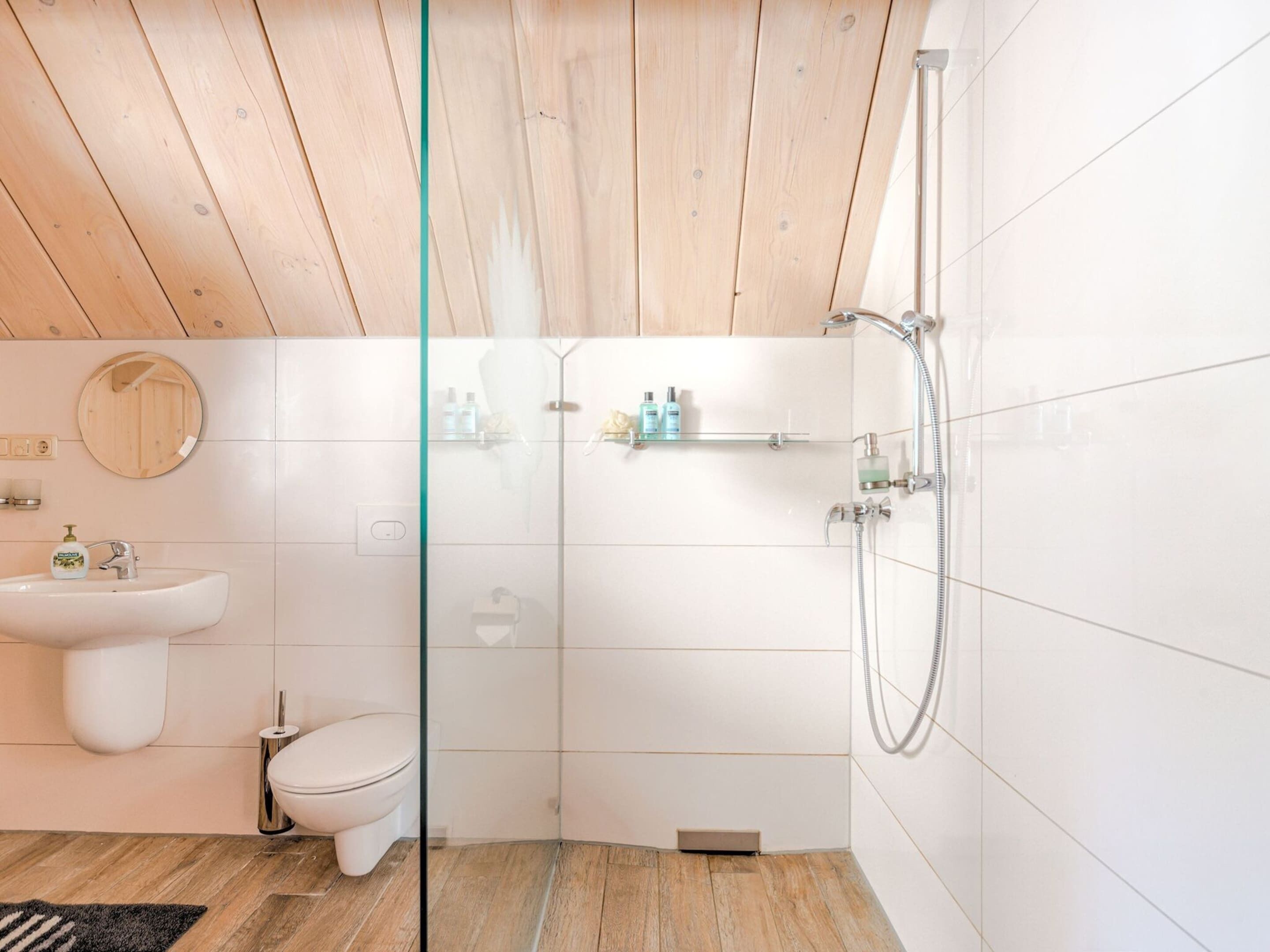 Une salle de bain moderne avec une douche à parois de verre, un lavabo et des toilettes.