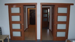 A hallway with two wooden doors leading to another room. - Hotel Arkadia (Plock)