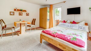 Une chambre à coucher comprenant un lit, un bureau, des chaises, une armoire et un téléviseur.