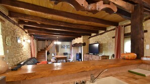 A rustic kitchen with a wooden countertop, a sink, and a stone wall. - Timeless Charm in Perigord (Saint-Leon-sur-Vezere)