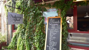 A restaurant with ivy-covered walls, a signboard with menu items, and a chalkboard menu. - Timeless Charm in Perigord (Saint-Leon-sur-Vezere)