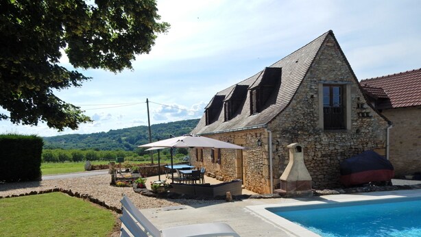 A stone building with a swimming pool, outdoor seating, and a view of the countryside. - Timeless Charm in Perigord (Saint-Leon-sur-Vezere)