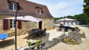 A stone building with a pool, outdoor seating, and umbrellas. - Timeless Charm in Perigord (Saint-Leon-sur-Vezere)