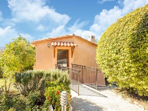 A small building with a tiled roof, a door, and a small porch with a railing. - Cozy Hillside Escape in Berre (Berre-des-Alpes)