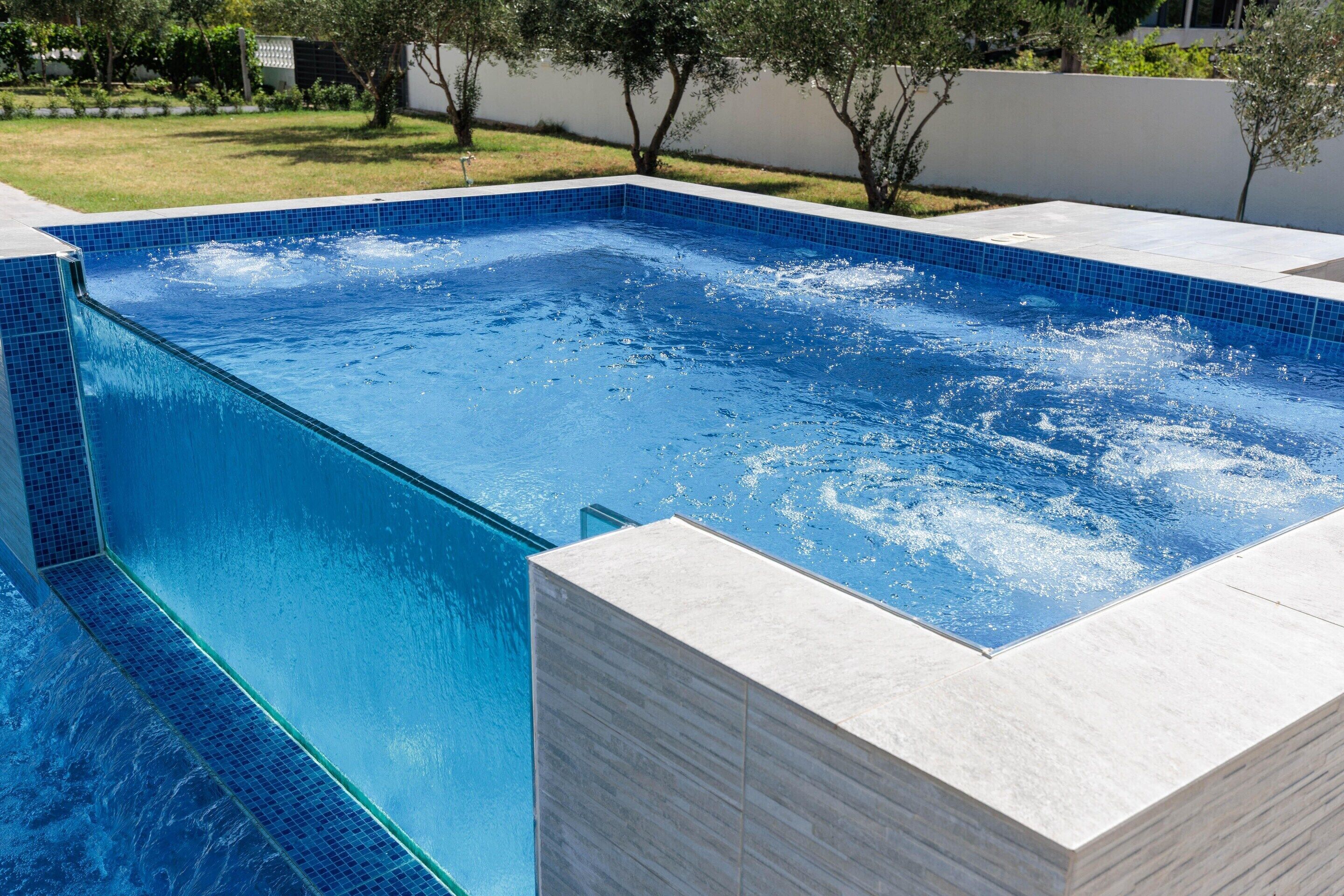 Una piscina rectangular amb aigua cristal·lina blava i vores enrajolades.