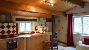 A kitchen with wooden cabinets, a built-in oven, a sink, and a stove. - House in Ardeche Near Ray-pic Falls (Saint-Pierre-de-Colombier)