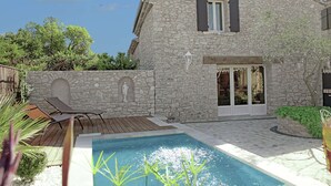 A stone building with a pool, outdoor seating, and a statue. - Bliss Near Aix-en-provence (Aix-en-Provence)