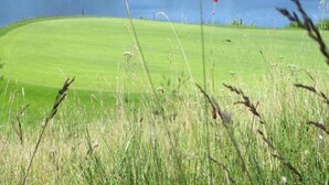 A golf course with a lake in the background. - Cozy Garden Retreat Malemort (Malemort-sur-Correze)