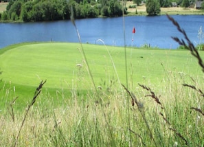 Un campo da golf con un lago sullo sfondo.