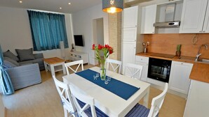 A modern apartment with a dining area, kitchen, and living room. - Holiday Home With Private Swimming Pool (Jasenice)