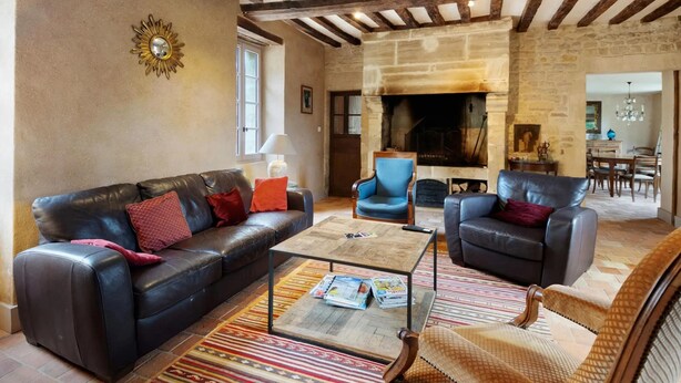 Ein Wohnzimmer mit Kamin, Ledersofas und einem Couchtisch.