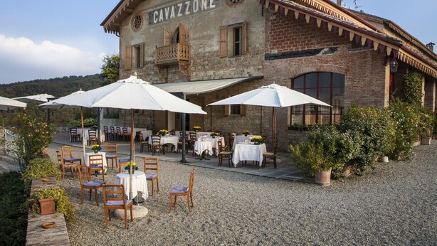 Un bâtiment portant l’enseigne « CAVAZZONE » et doté d’une terrasse avec des parasols.
