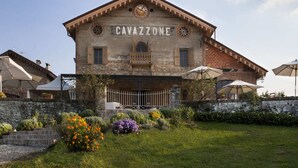Un bâtiment dont la façade porte l’inscription « CAVAZZONE », et qui présente un style architectural traditionnel avec un balcon et une horloge.