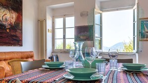Un coin repas avec une table dressée pour quatre personnes, agrémenté d’assiettes vertes et de verres transparents.