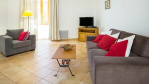 A living room with two sofas, a coffee table, a TV, and a lamp. - Montclus Charm: Views & Calm (Montclus)