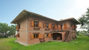 A two-story brick house with wooden shutters, a balcony, and a staircase leading to an upper level. - Exquisite Villa in Cesena With Sauna (Cesena)