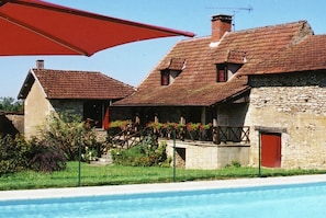 A traditional stone building with a swimming pool, a red umbrella, and a staircase leading to a porch. - Comfortable Holiday Home With Private Pool (Besse)