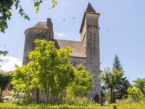 A historic stone tower with a conical roof, surrounded by lush greenery and a clear sky. - Comfortable Holiday Home With Private Pool (Besse)