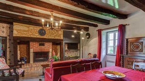 A dining area with a red tablecloth, a fireplace, and a chandelier. - Comfortable Holiday Home With Private Pool (Besse)