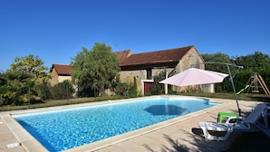 A swimming pool with a stone building in the background, a swing set, and a patio area with lounge chairs. - Comfortable Holiday Home With Private Pool (Besse)