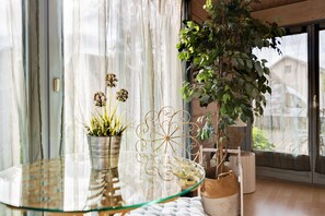 A glass table with a potted plant, a decorative metal piece, and a woven basket.