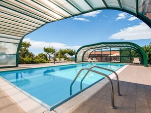 A swimming pool with a glass enclosure, surrounded by lounge chairs and a clear view of the sky. - Agriturismo in the Appenines with Covered Swimming Pool & Hot Tub (Apecchio)