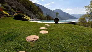 Eine Rasenfläche mit Pool, einem Kiesweg und einem Berg im Hintergrund.