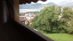 Blick aus einem Gebäude auf einen See und Berge.