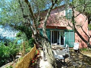 A rustic house with a garden, a wooden table, and a chair outside. - Cozy Holiday Home in Lerici near Sea (Lerici)