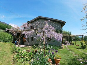 A stone house with a garden, a wooden pergola, and a clear sky. - Cozy Detached House, Wide Garden, Wifi (Paderno del Grappa)