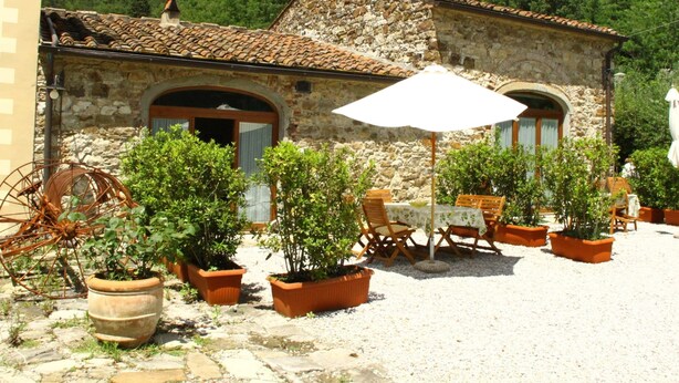 A stone building with a tiled roof, outdoor seating area with tables and chairs, and potted plants. - Idyllic Tuscan Hideaway With Pool and spa (Sesto Fiorentino)