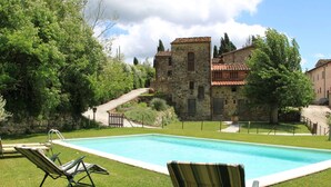 A swimming pool with two lounge chairs, surrounded by a well-maintained lawn and stone buildings in the background. - Idyllic Tuscan Hideaway With Pool and spa (Sesto Fiorentino)