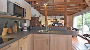 Una cocina moderna con armarios de madera, un microondas integrado y una isla grande con un fregadero.