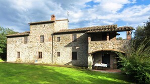 A stone building with a flat roof and a small tower.
