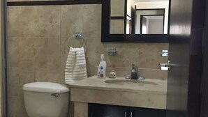 Un baño con inodoro, lavamanos y espejo.