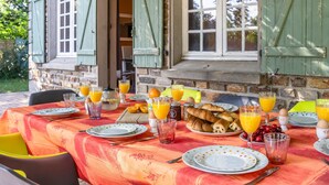 A breakfast table set with plates, glasses, and food items.
