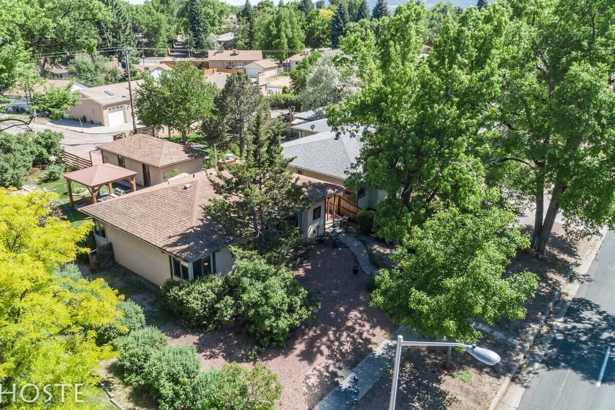 Un quartier résidentiel comprenant plusieurs maisons, un belvédère et un grand arbre.