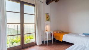 Une chambre avec une grande fenêtre, un bureau et un lit.