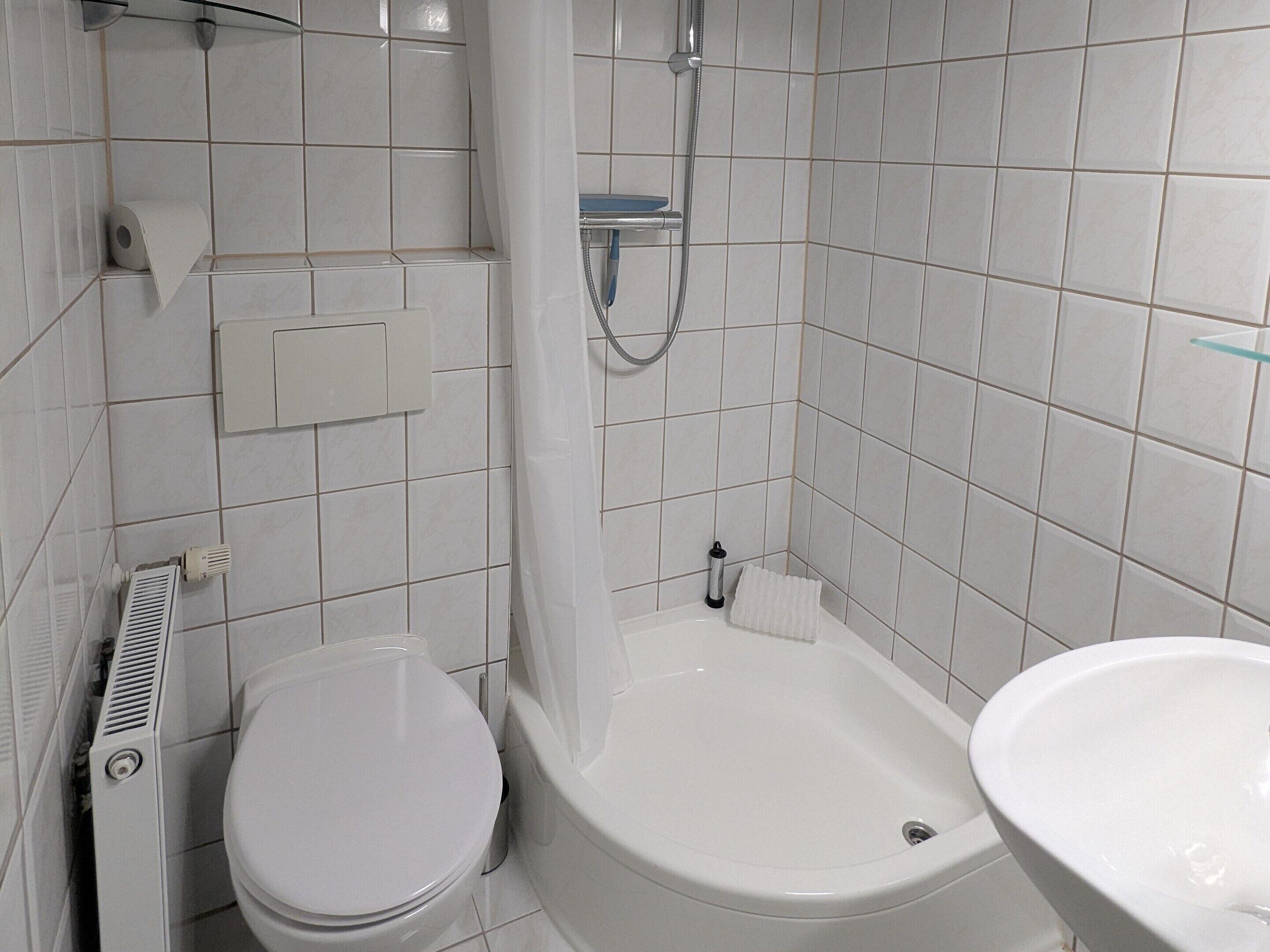 A bathroom with a toilet, a bathtub, and a sink.
