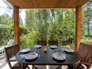 A wooden pergola with a table set for six, surrounded by lush greenery. - Family Escape in Les Salelles (Les Salelles)