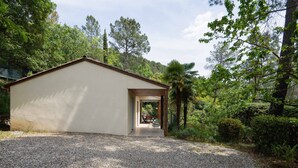 A building with a gravel driveway leading to a covered entrance. - Family Escape in Les Salelles (Les Salelles)