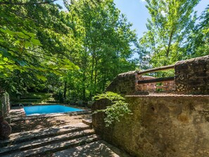 A stone staircase leading to a swimming pool surrounded by lush greenery and trees. - Holiday Home in Migliorini With Shared Pool (San Marcello Piteglio)