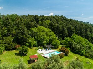 A pool area with a gazebo, lounge chairs, and a small deck. - Belvilla by OYO Casa Cielo (Pescia)