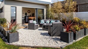 Una casa moderna con un patio amueblado y plantas.