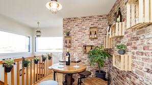 Un comedor acogedor con pared de ladrillo, muebles de madera y plantas en macetas.