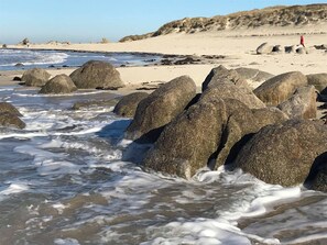 Na praia, espreguiçadeiras, toalhas de praia 